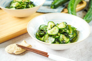 Sunomono (Japanese Cucumber Salad) in two bowls next to chopsticks and a taiyaki chopstick rest.