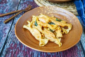 Sweet Potato Caramelle on a brown plate with crispy sage.