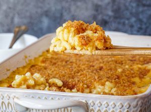 A scoop of Baked Macaroni and Cheese on a wooden spoon.