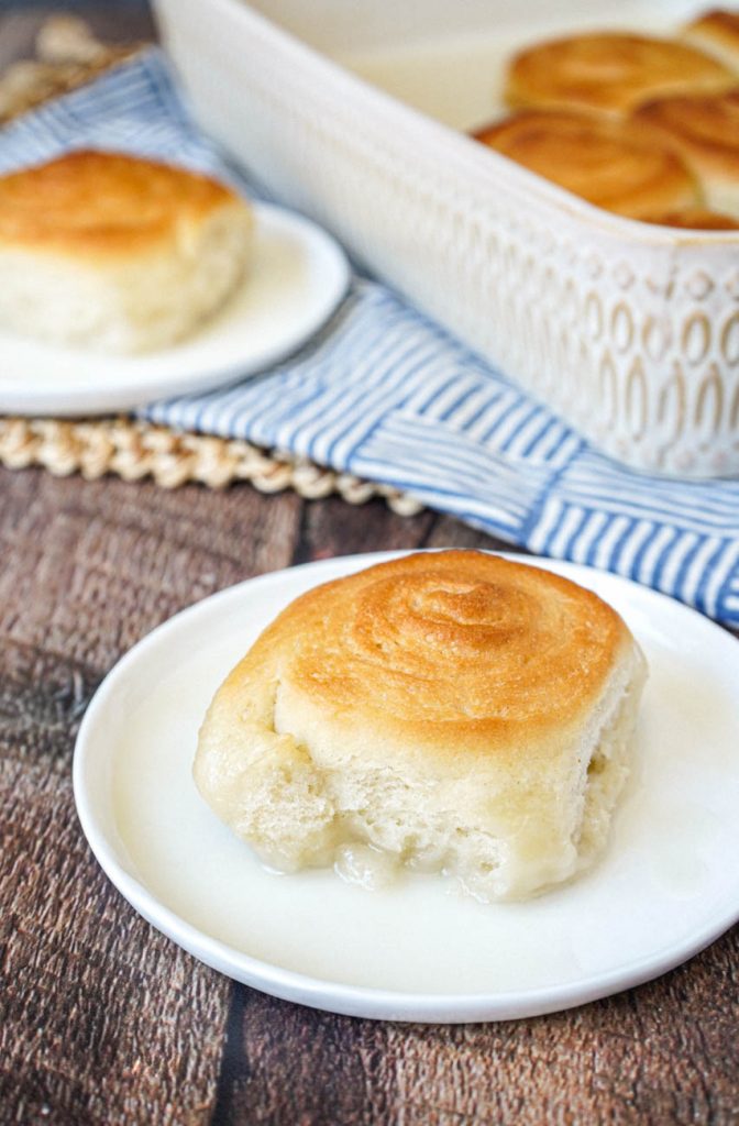 Pani Popo (Samoan Sweet Coconut Buns) on two white plates and in a baking dish.
