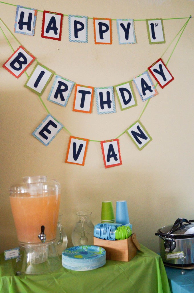 Happy Birthday Evan banner over a green table with drinks and paper cups.