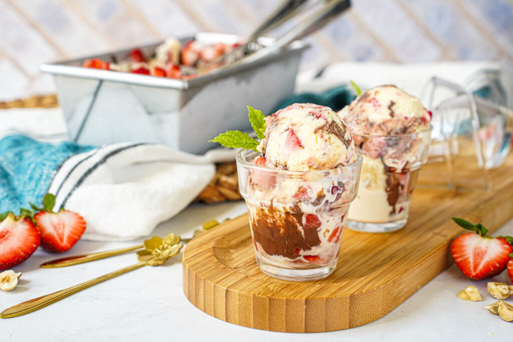 Strawberry Chocolate Hazelnut Ice Cream in two small bowls with a loaf pan in the background.