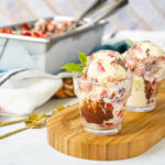 Strawberry Chocolate Hazelnut Ice Cream in two glasses with more in a loaf pan in the background.