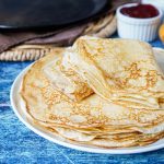 Blini (Russian Crepes) in a stack on a white plate.