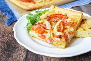 Two slices of Ladenia Milou on a white plate.