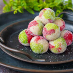 Stacks of Kaber Ellouz (Tunisian Almond Balls) on two platters with mint in the background.