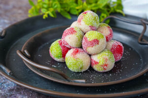 Stacks of Kaber Ellouz (Tunisian Almond Balls) on two platters with mint in the background.