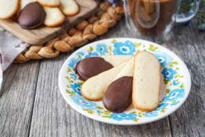 Plain and chocolate-dipped Langues de Chat (French Cat Tongue Cookies) on a blue flower plate.