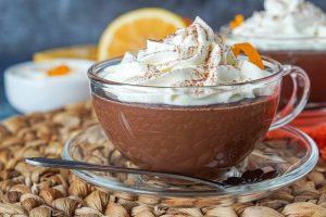 Cioccolata Calda (Italian Hot Chocolate) in a clear glass with orange whipped cream
