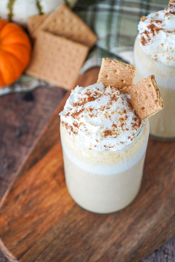 Close up of Pumpkin Cheesecake Smoothie with whipped cream and graham crackers.