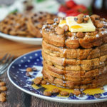 A stack of five Gingerbread Waffles on a blue and white plate.