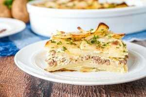 A slice Serbian Potato Musaka on a white plate.