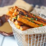 Spiced Sweet Potato Fries in a metal basket next to maple mustard dipping sauce.