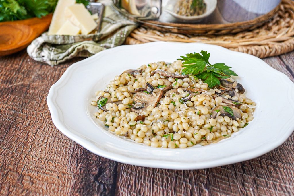 Pearl Couscous with Mushrooms Pearl Couscous with Mushrooms on a white plate topped with parsley.