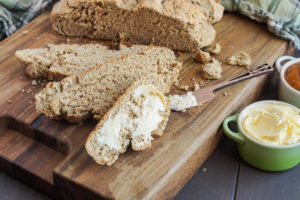 Irish Brown Bread on a wooden board cut into slices.