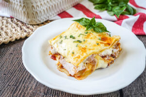 A slice of Pasticho (Venezuelan Lasagna) on a plate with fresh basil.