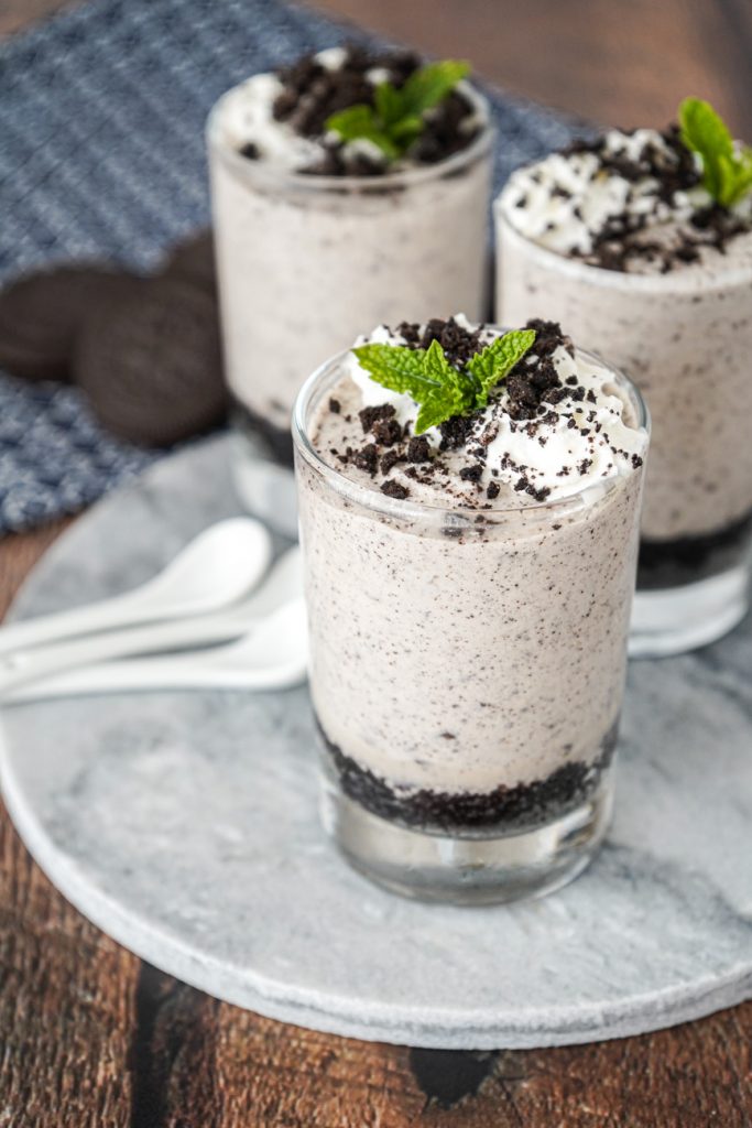 Cookies and Cream Mousse in three glasses with whipped cream and mint.