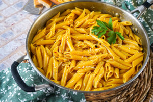 Penne allo Zafferano (Penne with Saffron) in a steel saucepan.