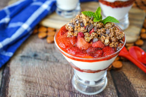 Roasted Strawberry Parfaits in clear glasses and topped with mint.