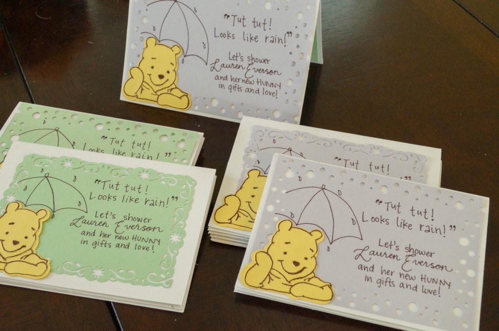Five Winnie the Pooh Invitations on a table with purple and green paper.