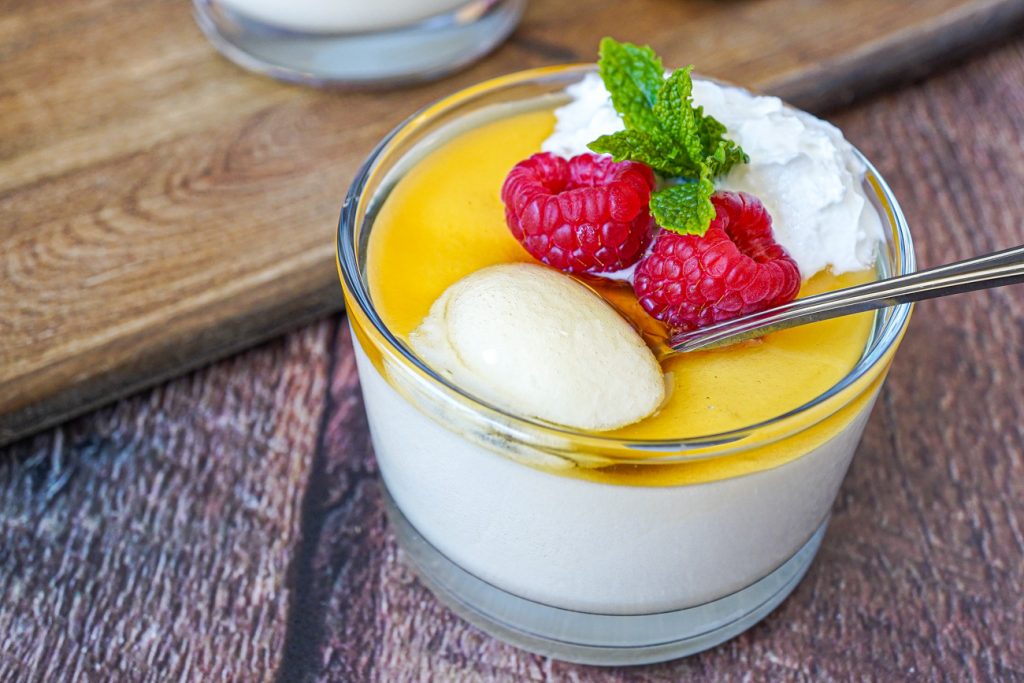 Honey White Chocolate Mousse in a glass cup with a spoonful of the mousse on top.
