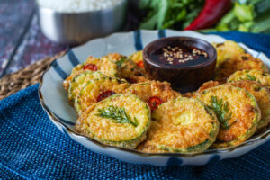 Hobak Jeon (Korean Pan-Fried Zucchini) on a plate with soy dipping sauce.