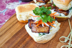 Pork Belly Slider with pork slices, mayonnaise, carrot, daikon, and cilantro.