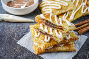 A stack of Brown Sugar Cinnamon Puff Pastries on a piece of parchment.