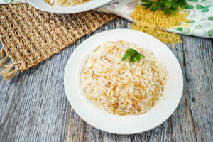 Arroz con Fideos (Dominican Rice with Noodles) on a white plate with fresh parsley.