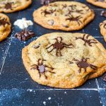 Spider Chocolate Chip Cookies on a black backdrop with chocolate spiders.