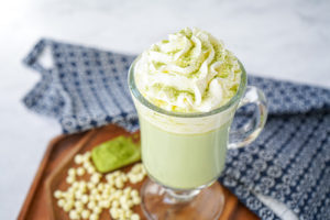Matcha Hot Chocolate in a tall glass with whipped cream on top.