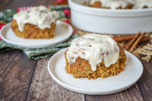 Two Gingerbread Cinnamon Rolls on two white plates.