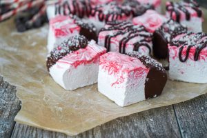 Peppermint Marshmallows with dark chocolate on brown parchment paper.