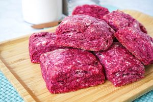 A pile of Beet Biscuits on a wooden platter.
