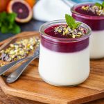 Blood Orange Panna Cotta in two jars next to two spoons.