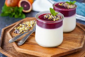 Blood Orange Panna Cotta in two jars next to two spoons.