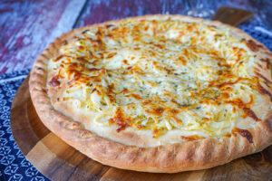 Fugazzeta (Argentinian Stuffed Pizza) on a wooden board.