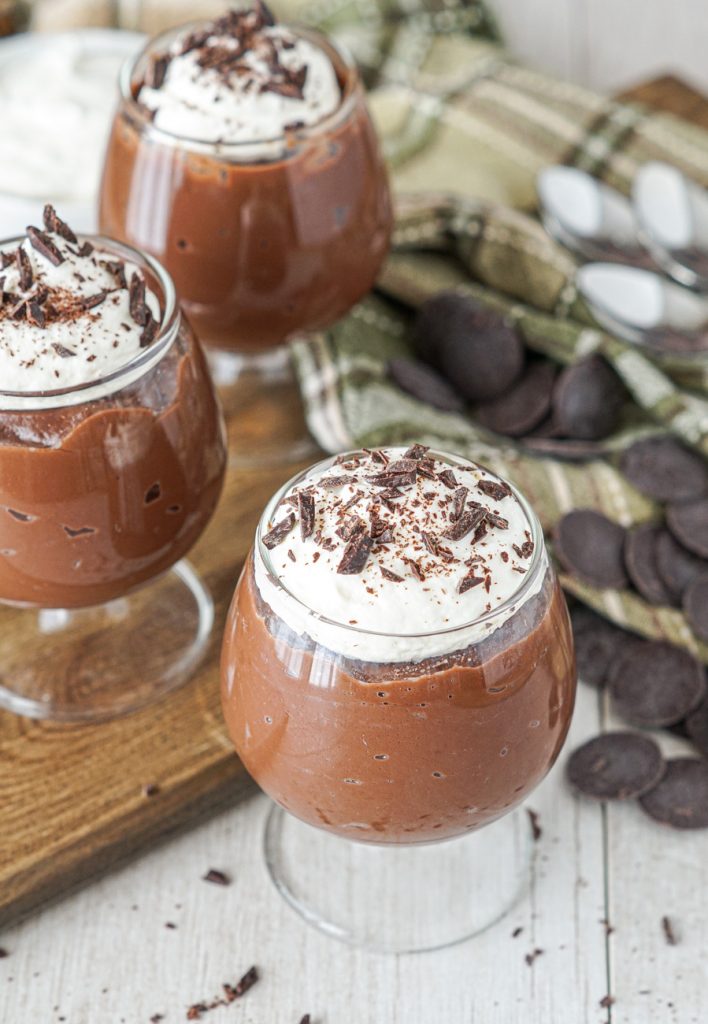 Irish Cream Dark Chocolate Pudding in three glasses topped with whipped cream and chocolate.