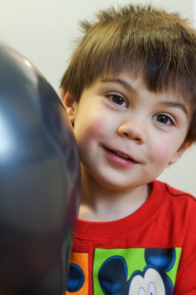 Boy holding a black balloon.