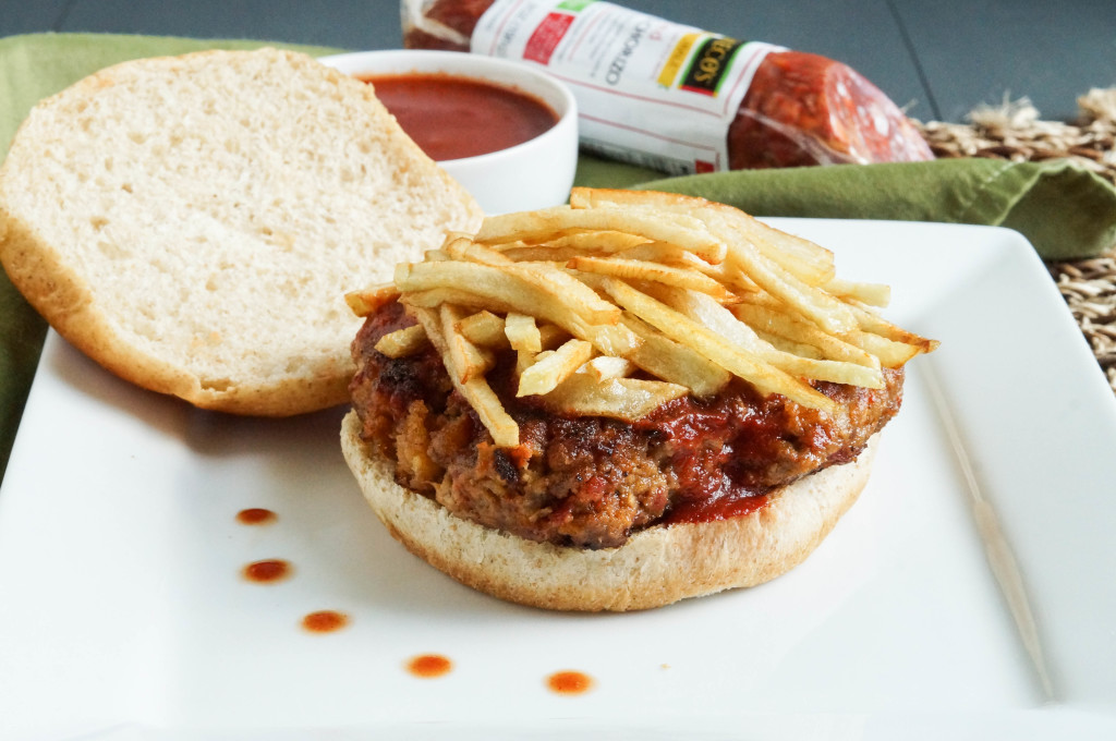 Frita Cubana (Cuban Hamburger) on a square white plate with fries on top.