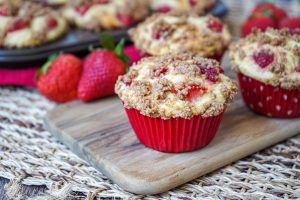 Strawberry Cheesecake Muffins on a wooden board.