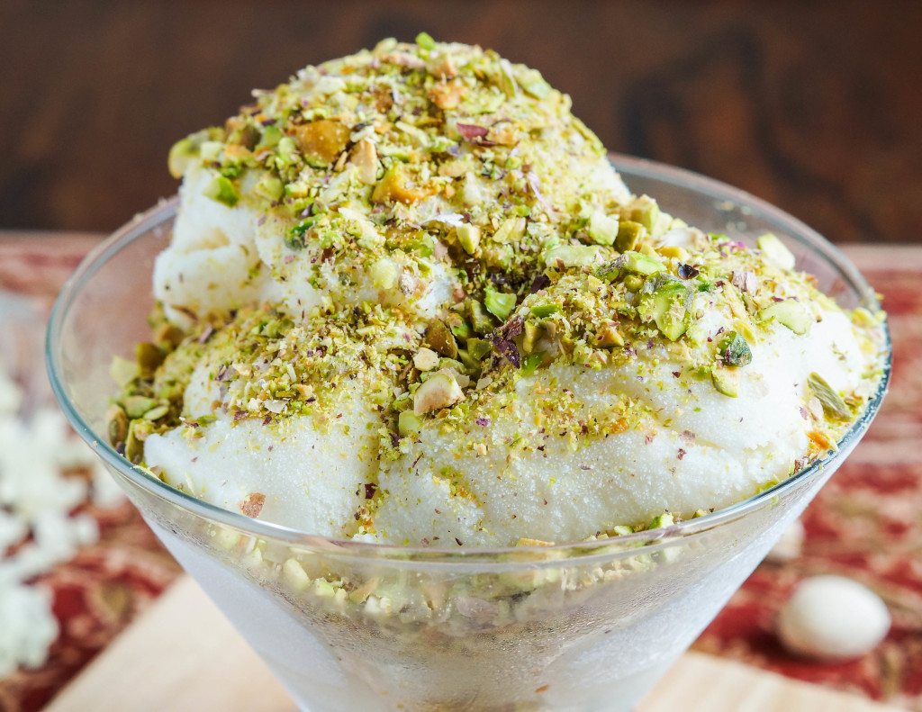 Close up of Éma’a (Syrian Ice Cream) in a glass bowl and covered with crushed pistachios.