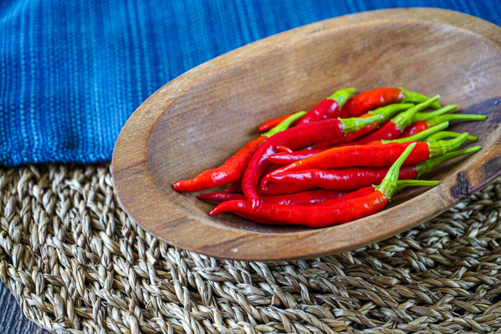 Red chilies in an oval wooden bowl.