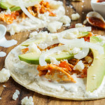 Chicken Tinga in corn tortilla with avocado, onion, and crumbled cheese.