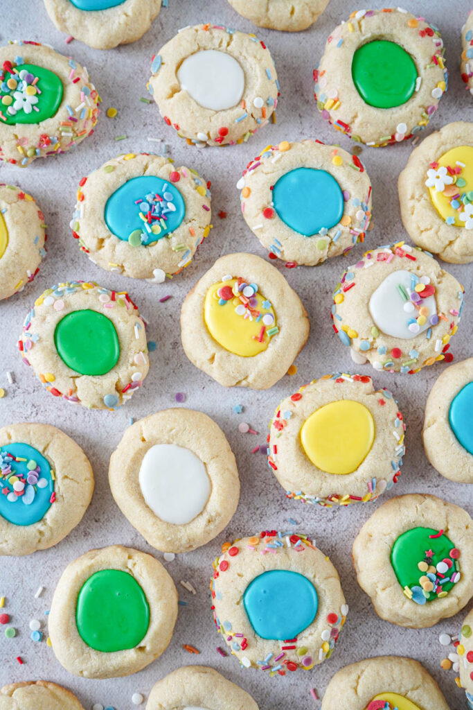Aerial view of Iced Thumbprint Cookies in a single layer with scattered sprinkles.