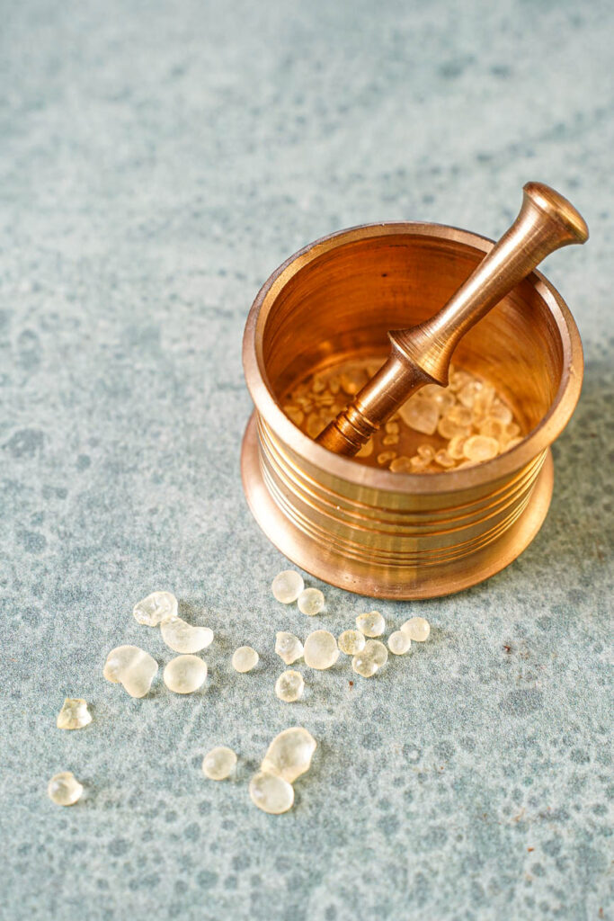 Mastic crystals in and next to a small mortar and pestle.