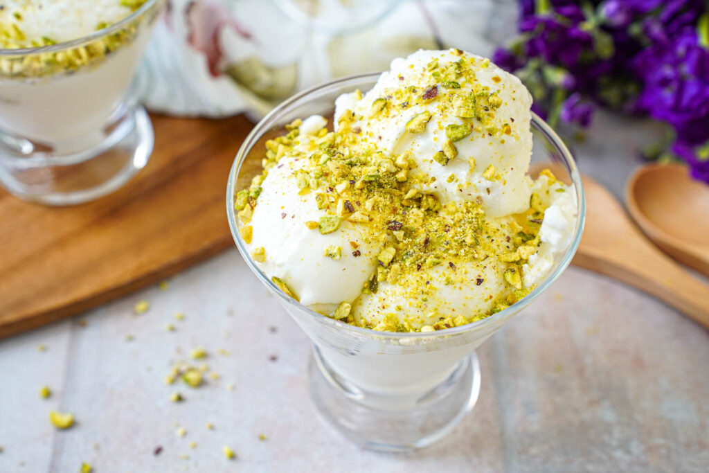 Mastic Ice Cream in a glass bowl with a covering of ground pistachios.