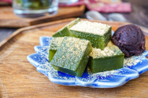 Matcha Jelly on a blue flower plate with kinako and red bean paste.