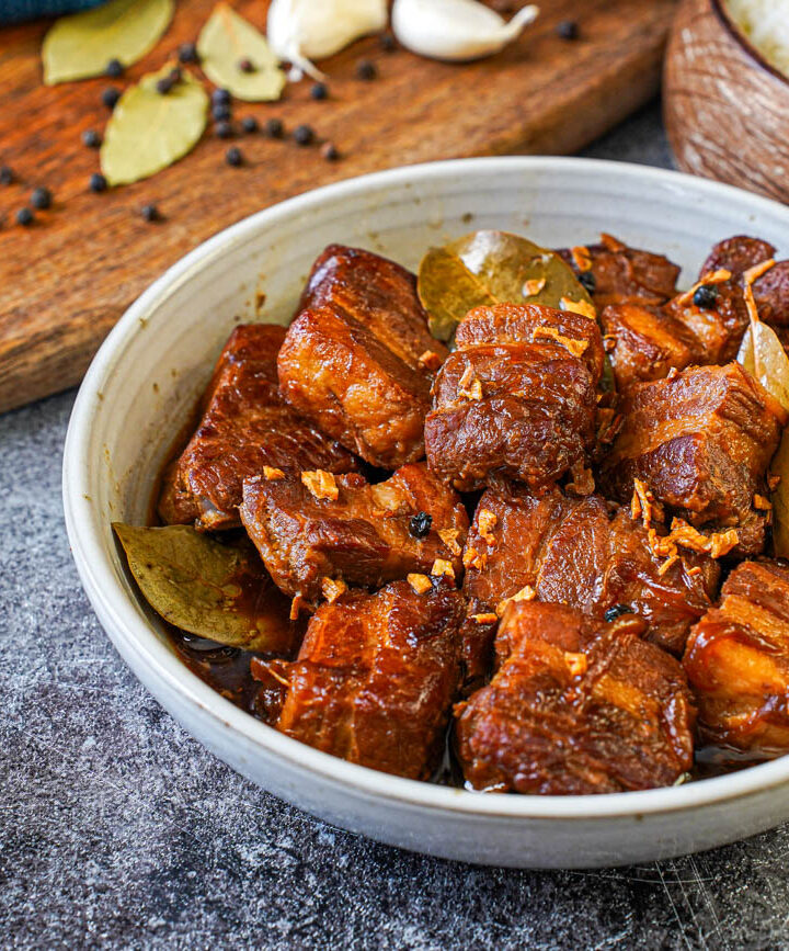 Adobong Baboy (Filipino Pork Adobo) in a bowl next to a bowl of rice.