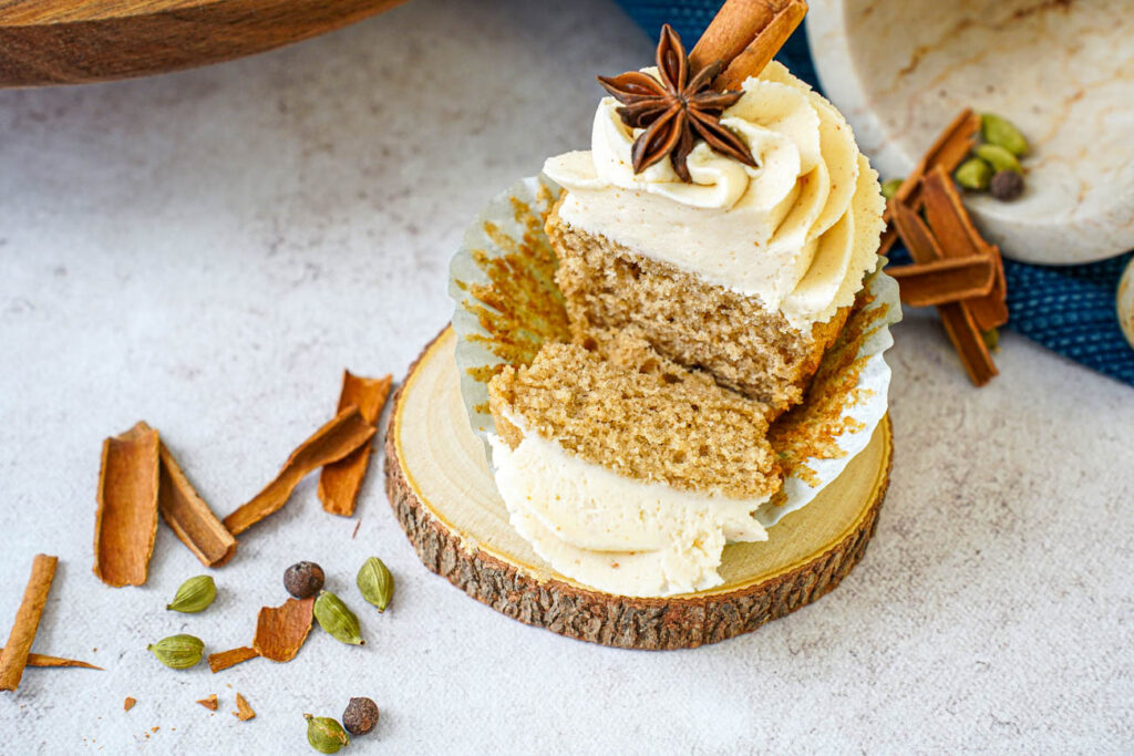 Chai Cupcakes with Brown Butter Frosting with part cut off to show cake interior.